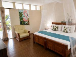a bedroom with a large bed and a chair at Rancho el Sobrino in Sabana Westpunt +143 photos