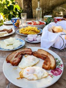a plate of breakfast food with eggs sausage and french fries at Apartment Lake Oasis ''Oko'' in Krnjice