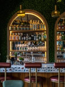 a bar with stools in front of a wall at Hotel Boutique Lafayette Tijuana in Tijuana