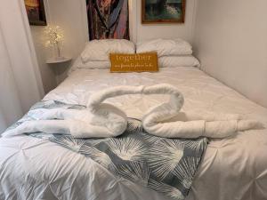 a pair of swans laying on a bed at Romantic Beach Style Cottage close to everything! in Whitehouse Plantation