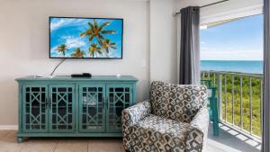 a living room with a chair and a view of the ocean at Key Largo 2BR 2BA Oceanfront with Pool in Tavernier +44 photos