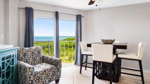 a dining room with a table and chairs and a view of the ocean at Key Largo 2BR 2BA Oceanfront with Pool in Tavernier