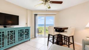 a living room with a television and a table and chairs at Key Largo 2BR 2BA Oceanfront with Pool in Tavernier