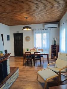 a living room with a table and chairs and a fireplace at Betty's Garden House in Nea Anchialos