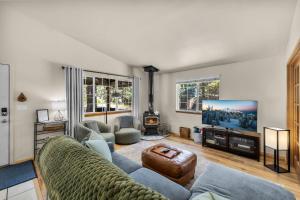 ein Wohnzimmer mit Sofa und Fernseher in der Unterkunft Indio Cabin - Meredith Lodging in Bend