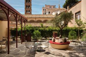a patio with a table and chairs and a tree at Hotel Urbana, a Tribute Portfolio Hotel in Rome
