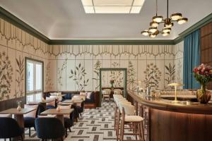 a restaurant with a bar and tables and chairs at Hotel Urbana, a Tribute Portfolio Hotel in Rome