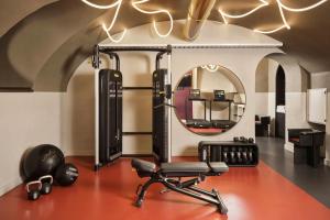 a gym with a chair and a mirror at Hotel Urbana, a Tribute Portfolio Hotel in Rome