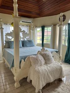 a bedroom with a white canopy bed with two pillows at Elite stays in Santa Cruz
