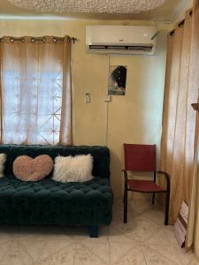 a living room with a green couch and a red chair at Elite stays in Santa Cruz