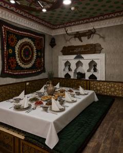 a dining room with a table with food on it at Green City Hotel ШАХРИСАБЗ in Khujand