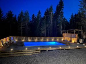a large swimming pool with a fence and lights at Seeblickwohnung Aäng 6 Pool, Billard in Mjöhult