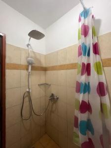 a bathroom with a shower with a colorful shower curtain at Vila CANO Boutique in Durrës +24 photos