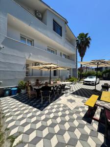 a patio with tables and umbrellas in front of a building at Vila CANO Boutique in Durrës