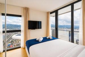 a bedroom with a large bed with a large window at Orbi City Panorama Hotel & Sea View Balcony in Batumi +86 photos