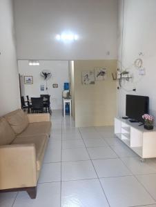 a living room with a couch and a tv at Casa de Praia Recanto Flecheiras in Trairi