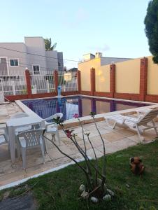 a patio with a table and a bench and a pool at Casa de Praia Recanto Flecheiras in Trairi