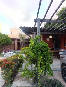 a garden with a wooden pergola and some flowers at Casa de Praia Recanto Flecheiras in Trairi