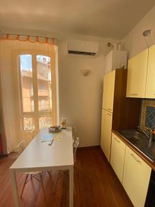 a kitchen with a white table and a white refrigerator at Appartamento Pop Art in Centro in Biella
