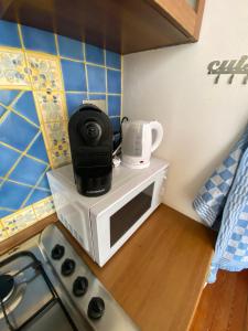 a microwave with a coffee maker on top of it at Appartamento Pop Art in Centro in Biella