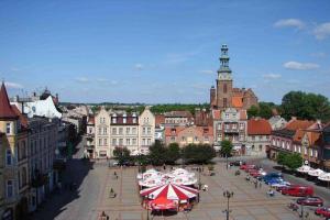 a city with a street with cars and umbrellas at Sercowe Zacisze in Chełmża