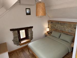 a small bedroom with a bed and a window at La Petite Grange in Aywaille