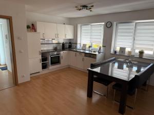 eine Küche mit weißen Schränken und einem Tisch darin in der Unterkunft rottweilsuite in Villingendorf