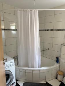 eine Badewanne mit Duschvorhang im Badezimmer in der Unterkunft rottweilsuite in Villingendorf + 15 Fotos