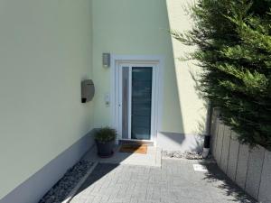 eine Tür zu einem Gebäude mit einer Pflanze daneben in der Unterkunft rottweilsuite in Villingendorf