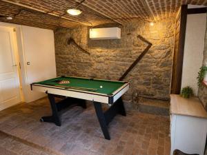 a ping pong table in a room with a brick wall at La Petite Grange in Aywaille