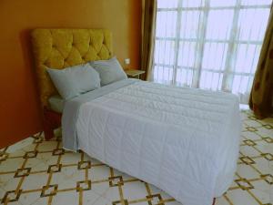 a bedroom with a large bed with a white comforter at Kio Farm Retreat in Kiserian