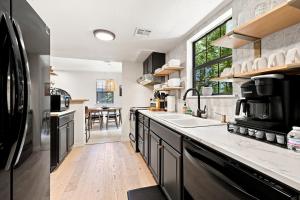 a kitchen with black cabinets and a large window at Gravity Getaway in Bella Vista