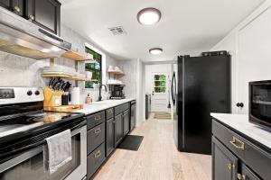 a large kitchen with a black refrigerator and counters at Gravity Getaway in Bella Vista