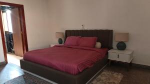 a bedroom with a large bed with pink pillows at Villas HouN Assinie in Mafia