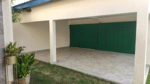 an empty garage with a green garage door at Villas HouN Assinie in Mafia