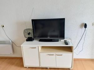a flat screen tv on a white stand in a room at Apartmani Ribar in Ohrid