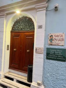 a wooden door on a building with a sign in front at Villa Santa Chiara in Loreto