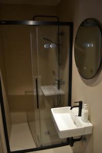 a bathroom with a shower and a sink and a mirror at Can Hortafa in Tortellá