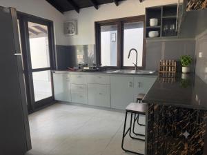 a kitchen with white cabinets and a counter top at ANABEE HOLIDAY Inn in Jaffna