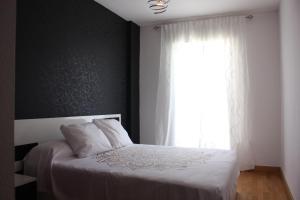 una camera con un letto bianco e una finestra di Sea and Light a Isla Cristina