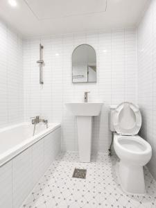 a white bathroom with a sink and a toilet at Stay brick in Seoul