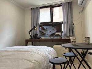 a bedroom with a bed and a table and a window at Stay brick in Seoul +5 photos