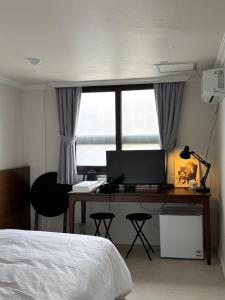a bedroom with a bed and a desk with a computer at Stay brick in Seoul