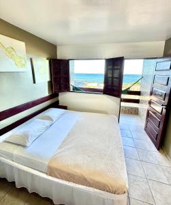 a bedroom with a bed with a view of the ocean at Pousada Legno Bossa Nova in Maceió
