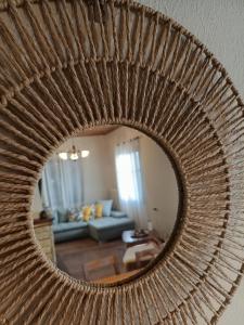a mirror reflecting a living room with a couch at Betty's Garden House in Nea Anchialos +24 photos