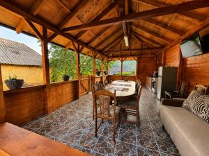 a dining room with a table and a couch at Cabanele din livadă in Corbi