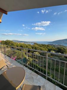 a balcony with a table and a view of the ocean at Vila Denda Herceg Novi in Herceg-Novi