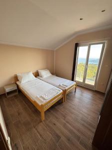 a bedroom with a large bed with a large window at Vila Denda Herceg Novi in Herceg-Novi