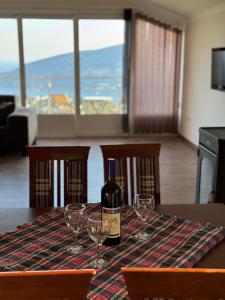a bottle of wine sitting on a table with wine glasses at Vila Denda Herceg Novi in Herceg-Novi