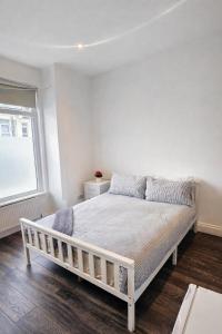 a white bed in a white room with a window at Studio Flat London in The Hyde